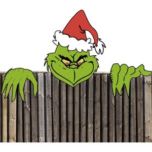 A solid wood 2d decoration of a grinch peering over a fence