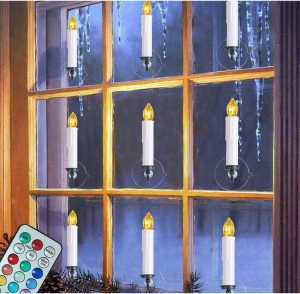 White candles with yellow plastic flames suction cupped onto a window used as Farmhouse Christmas Decor