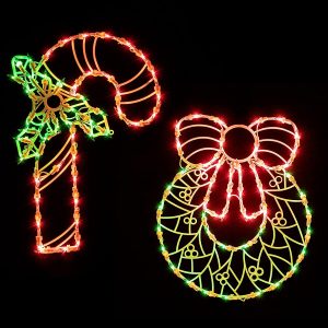 Two lighted silhouettes, one is a red candy cane with holly on it, the other is a yellow wreath with a red bow