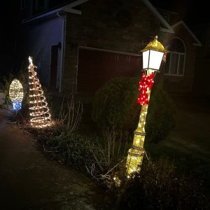 Warm white lighted wire frame decorations including a lamp post with a red bow, a spiral tree and a 3 foot tall light bulb